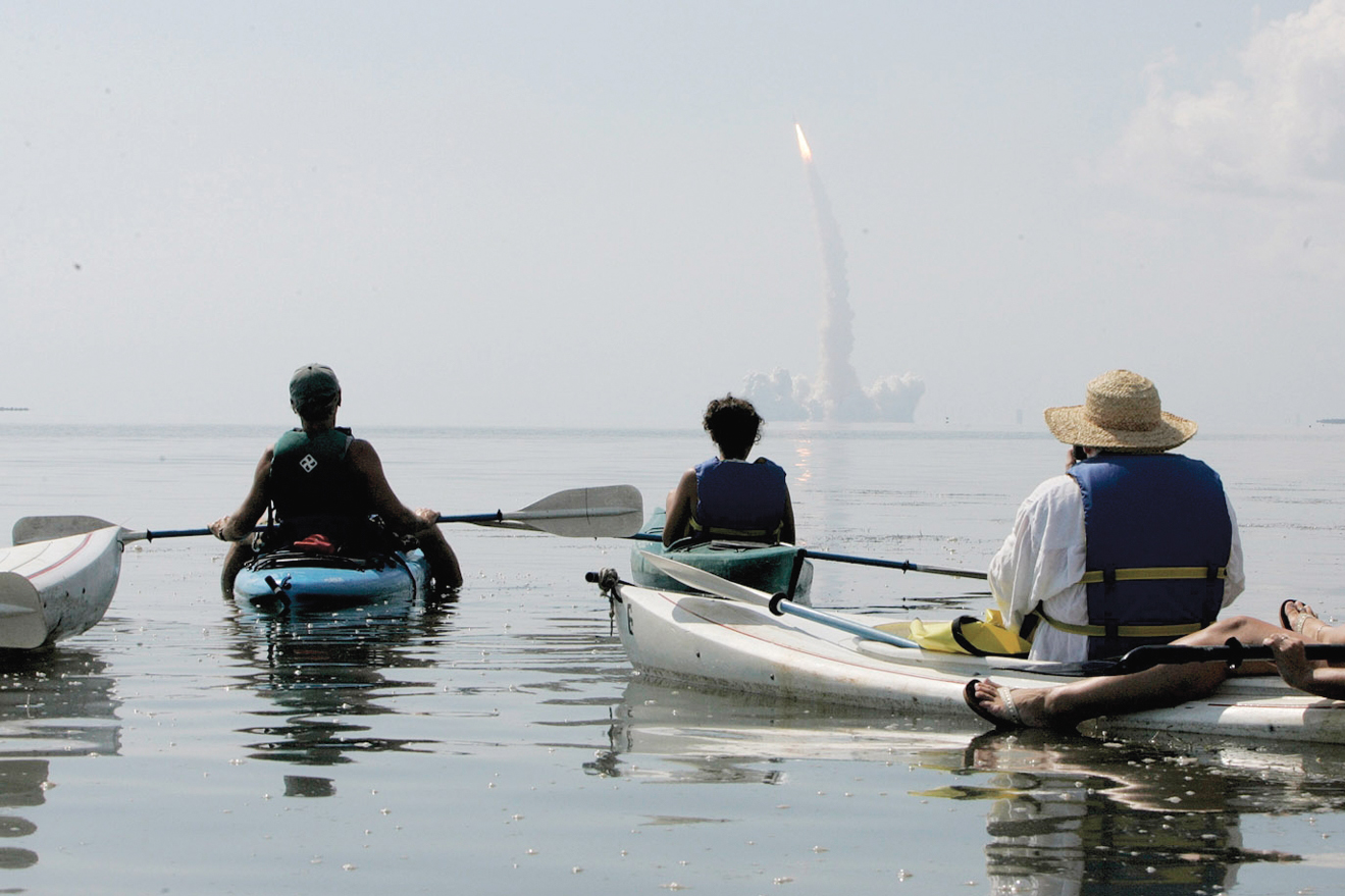 Mike Mahan (L), owner of Day Away Kayak Tours in Titusville, Florida, leads a group of 14 kayaks to Mosquito Lagoon in the Merritt Island Wildlife Refuge to watch the space shuttle Discovery lifts off the launch pad at Kennedy Space Center July 26, 2005. REUTERS/Mark Wallheiser