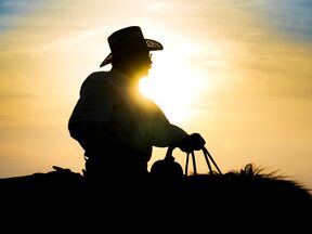 Im Sonnenuntergang reitender Cowboy in den Flint Hills in Kansas