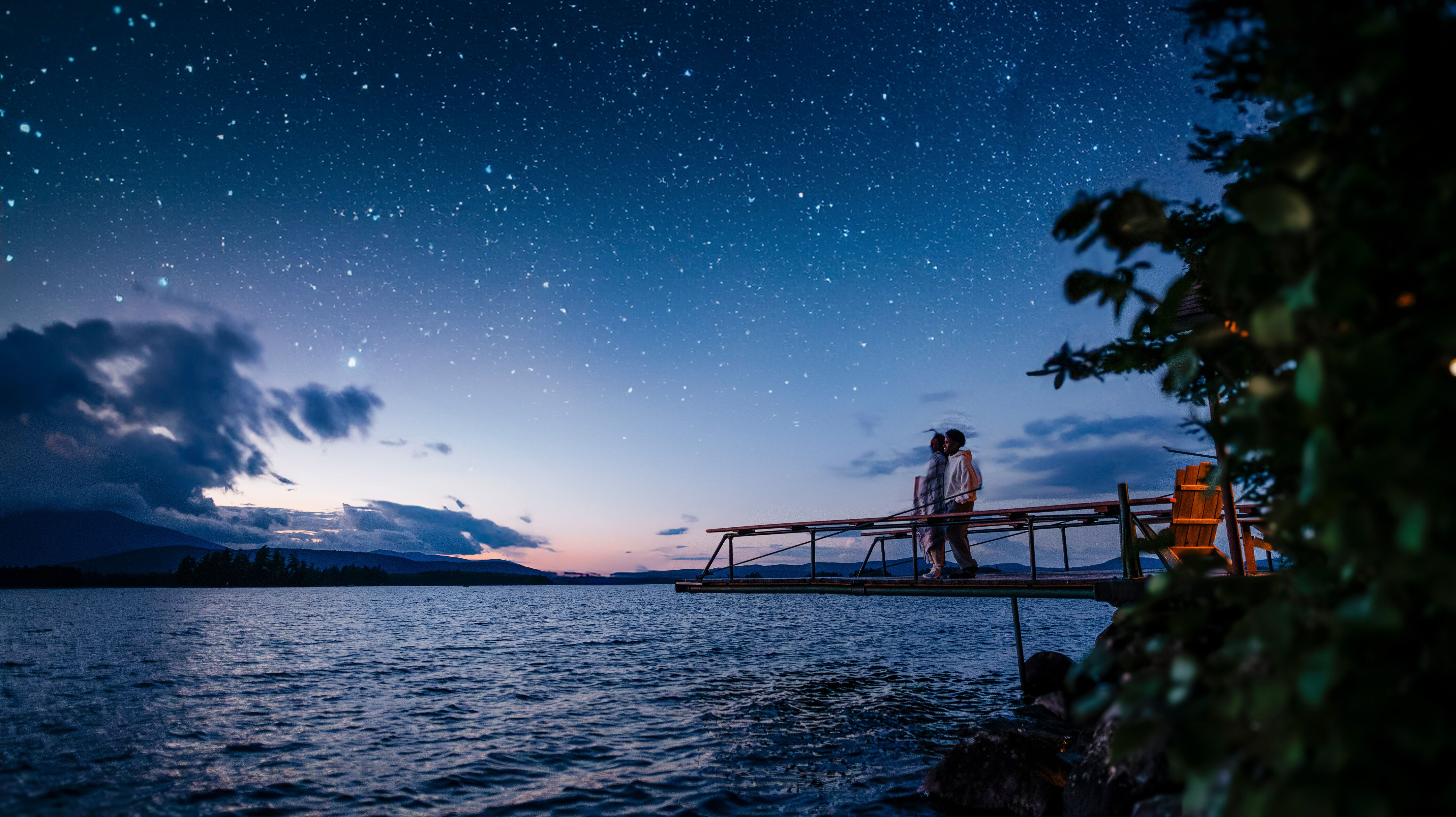 Paar beobachtet den Sternenhimmel in Maine am See Paar beobachtet den Sternenhimmel in Maine am See