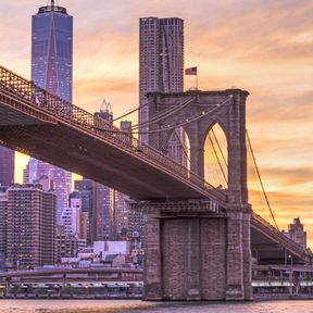 Blick auf die Brooklyn Bridge und das One World Trade Center bei Sonnenuntergang