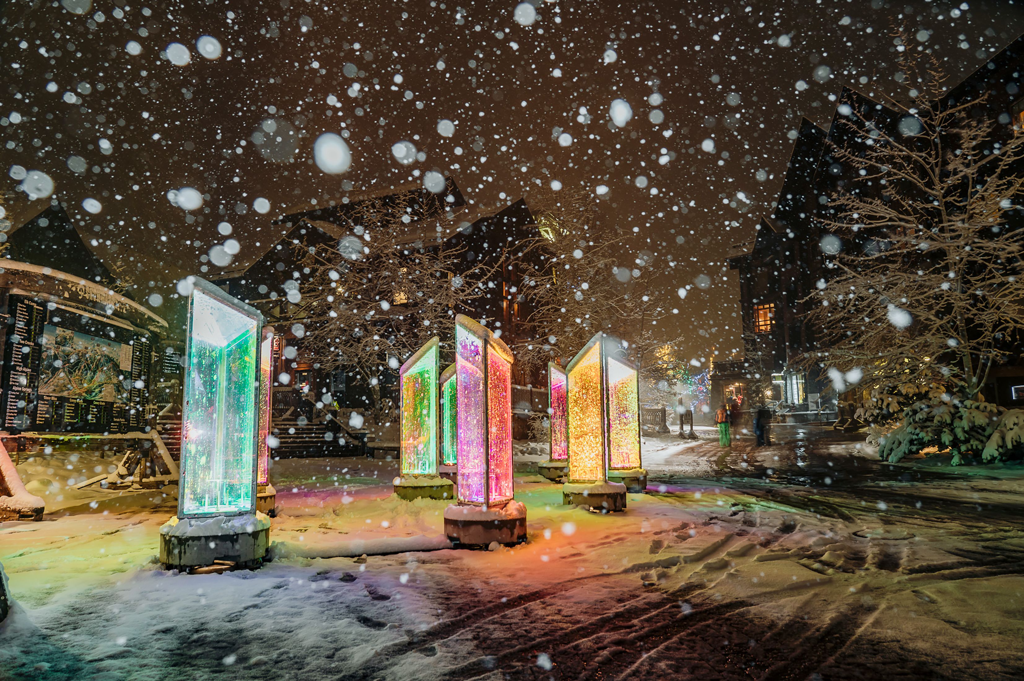 Kunstinstallation leuchtende Säulen im abendlichen Schneegestöber