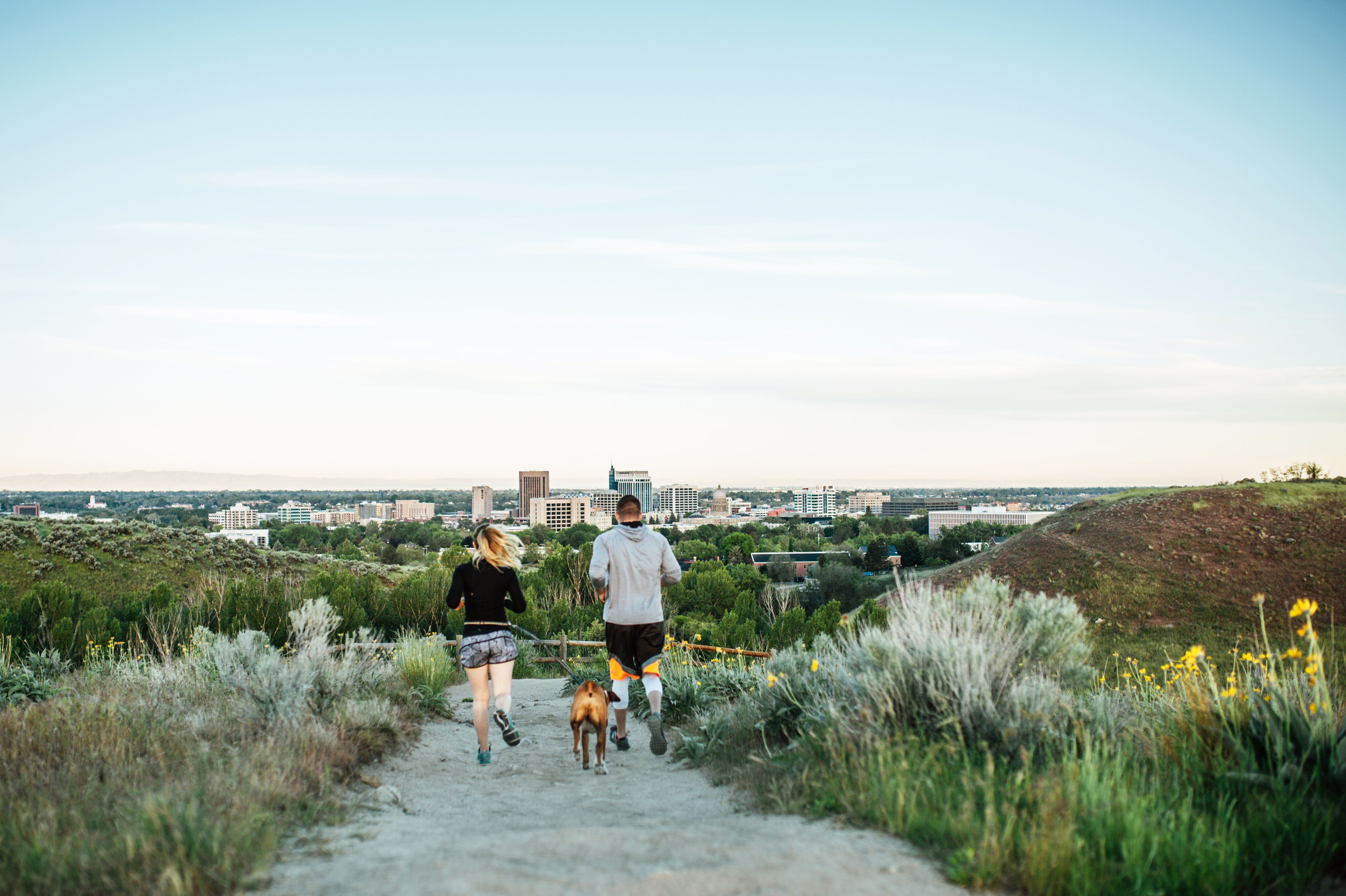 Jogger mit treuem Begleiter auf einem Ridge to Rivers Trail in Boise