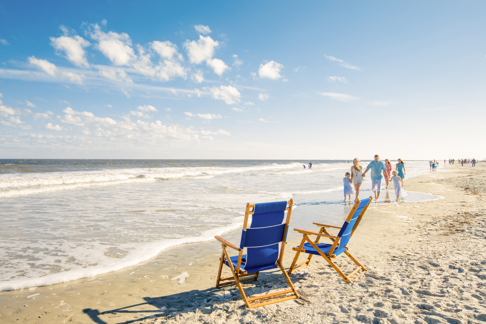 Strand mit Wasser, Liegestühlen und Familien auf Tybee Island, Georgia