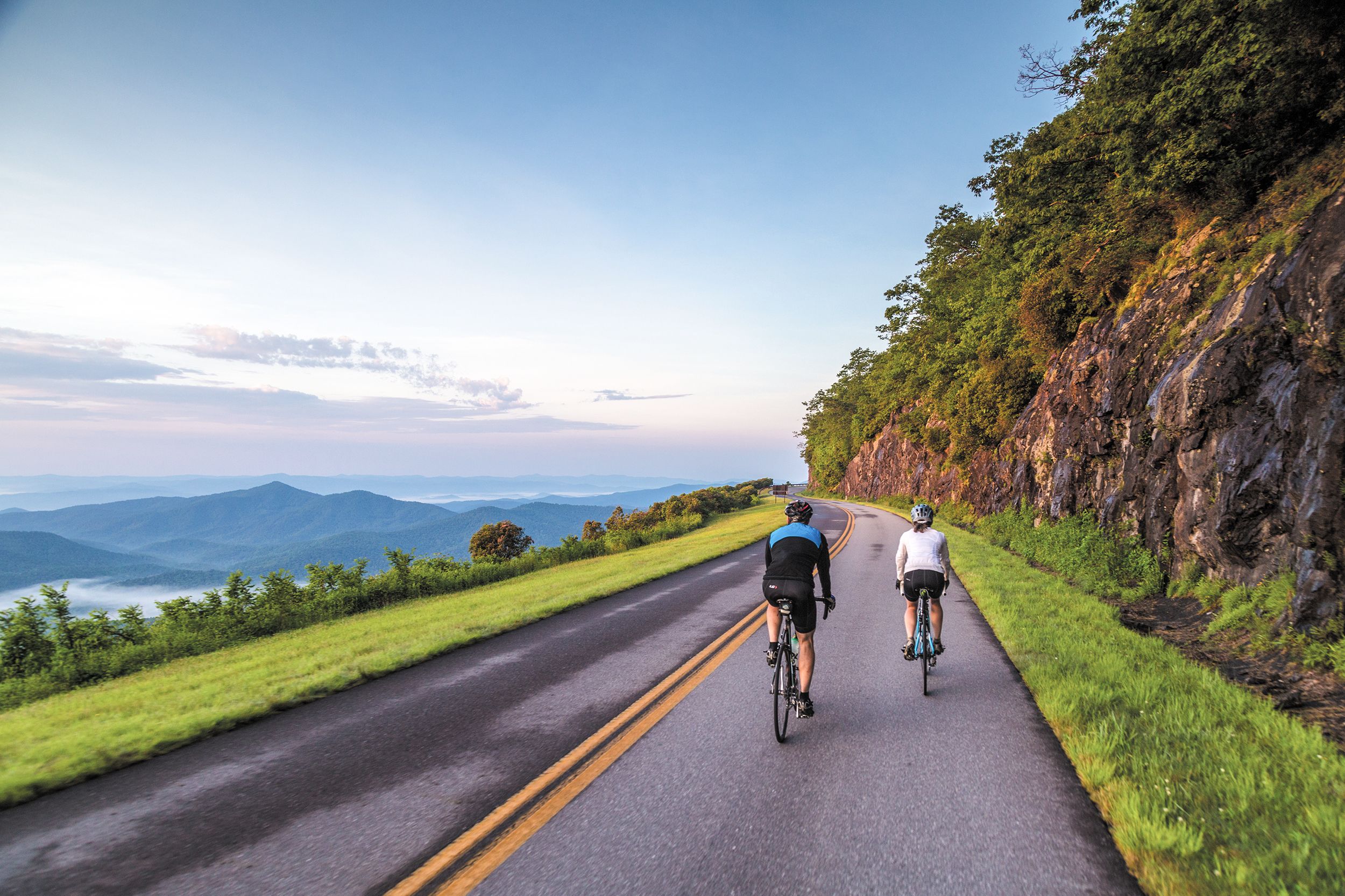 Ein Radfahrerpaar auf dem Blue Ridge Parkway bei Sonnenaufgang in North Carolina