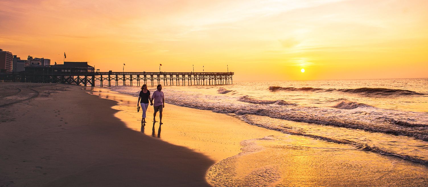 Bei Sonnenaufgang am Strand von Myrtle Beach entlang spazieren