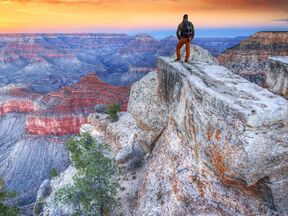 Ein Mann bei Sonnenaufgang im Grand Canyon