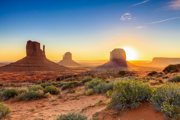 Die Sonne beleuchtet das markante Monument Valley auf dem Gebiet der Navajo in Arizona Die Sonne beleuchtet das markante Monument Valley auf dem Gebiet der Navajo in Arizona