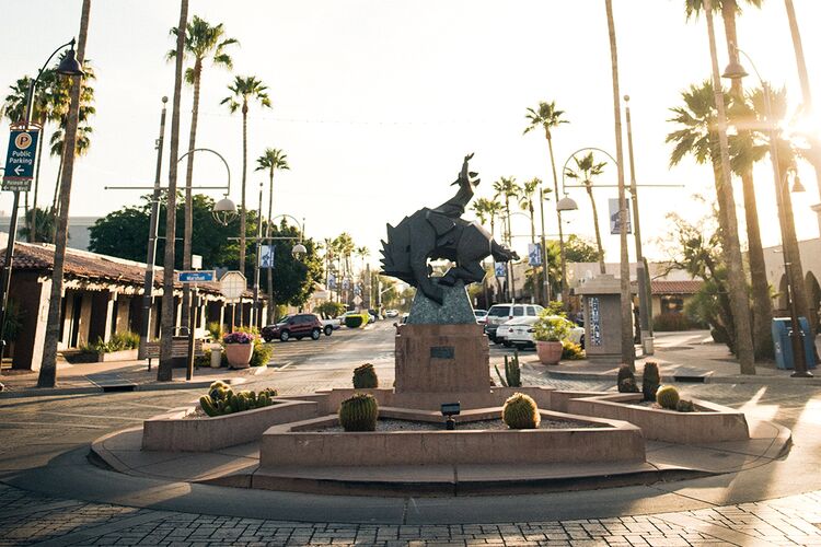 Palmen umkreisen eine kunstvolle Staue in Scottsdale