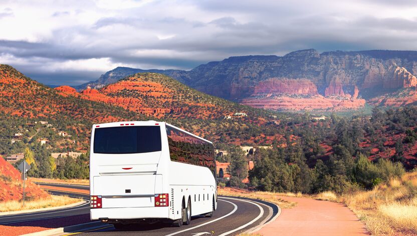 Ein Reisebus fährt durch die Landschaft bei Sedona in Arizona Ein Reisebus fährt durch die Landschaft bei Sedona in Arizona