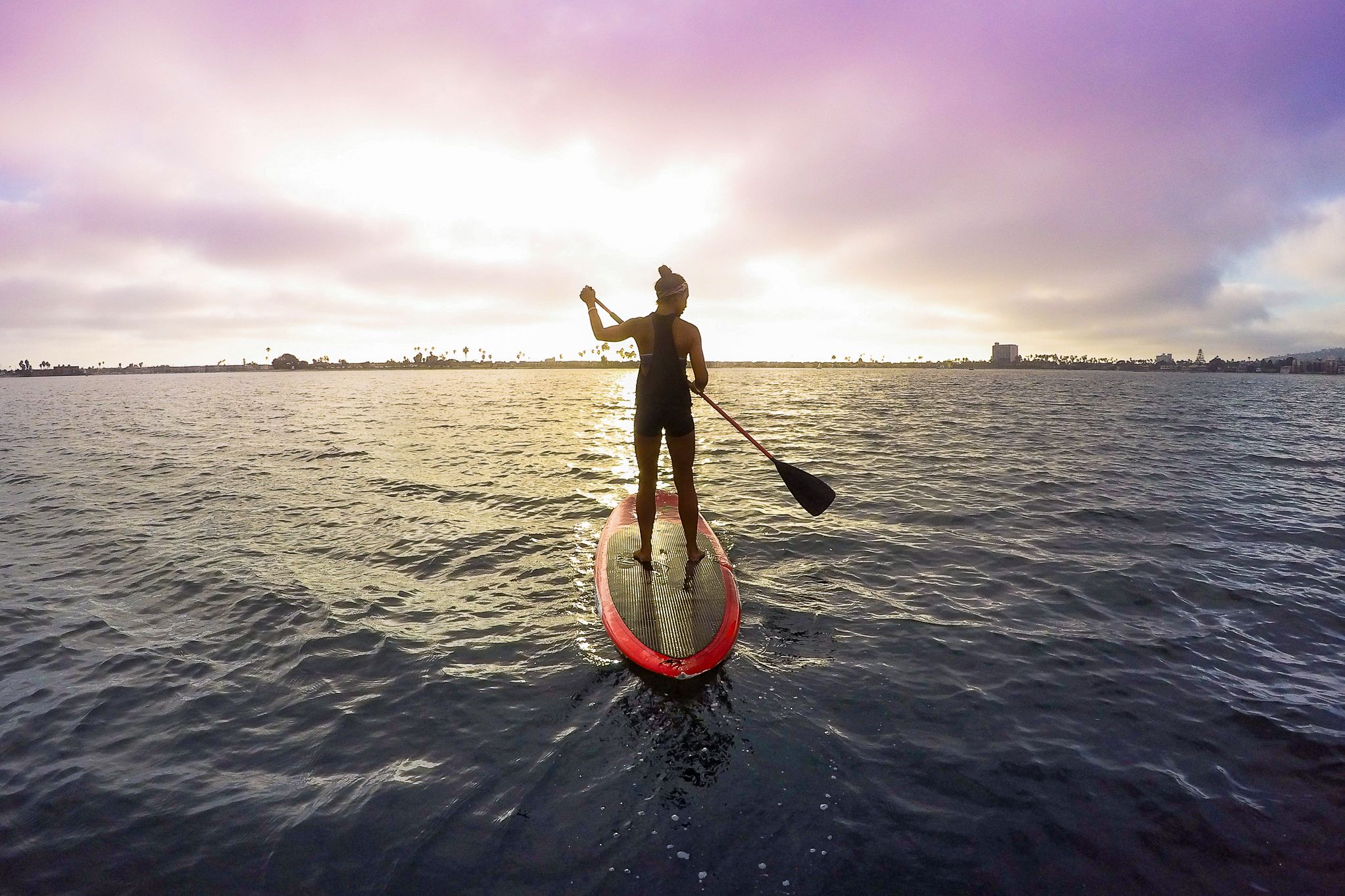 Eine Stand-Up Paddlerin unterwegs in dem Stadtteil Mission Bay in San Diego, Kalifornien