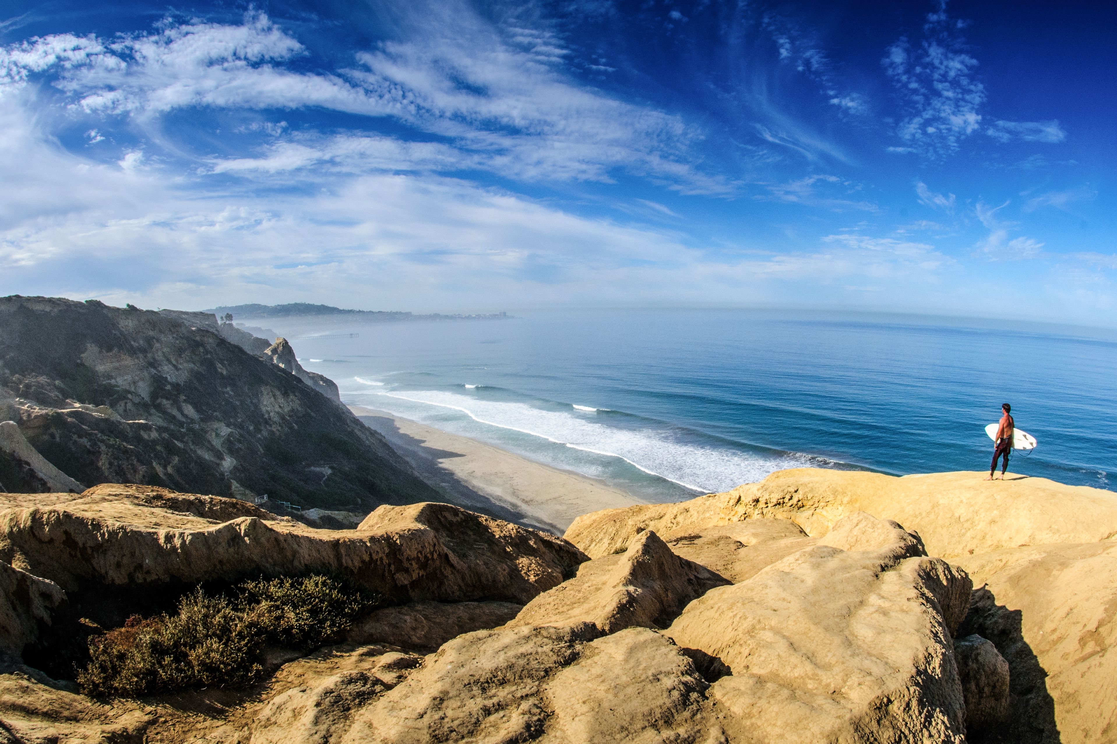 Ein Surfer beobachtet die Wellen am Strand von San Diego