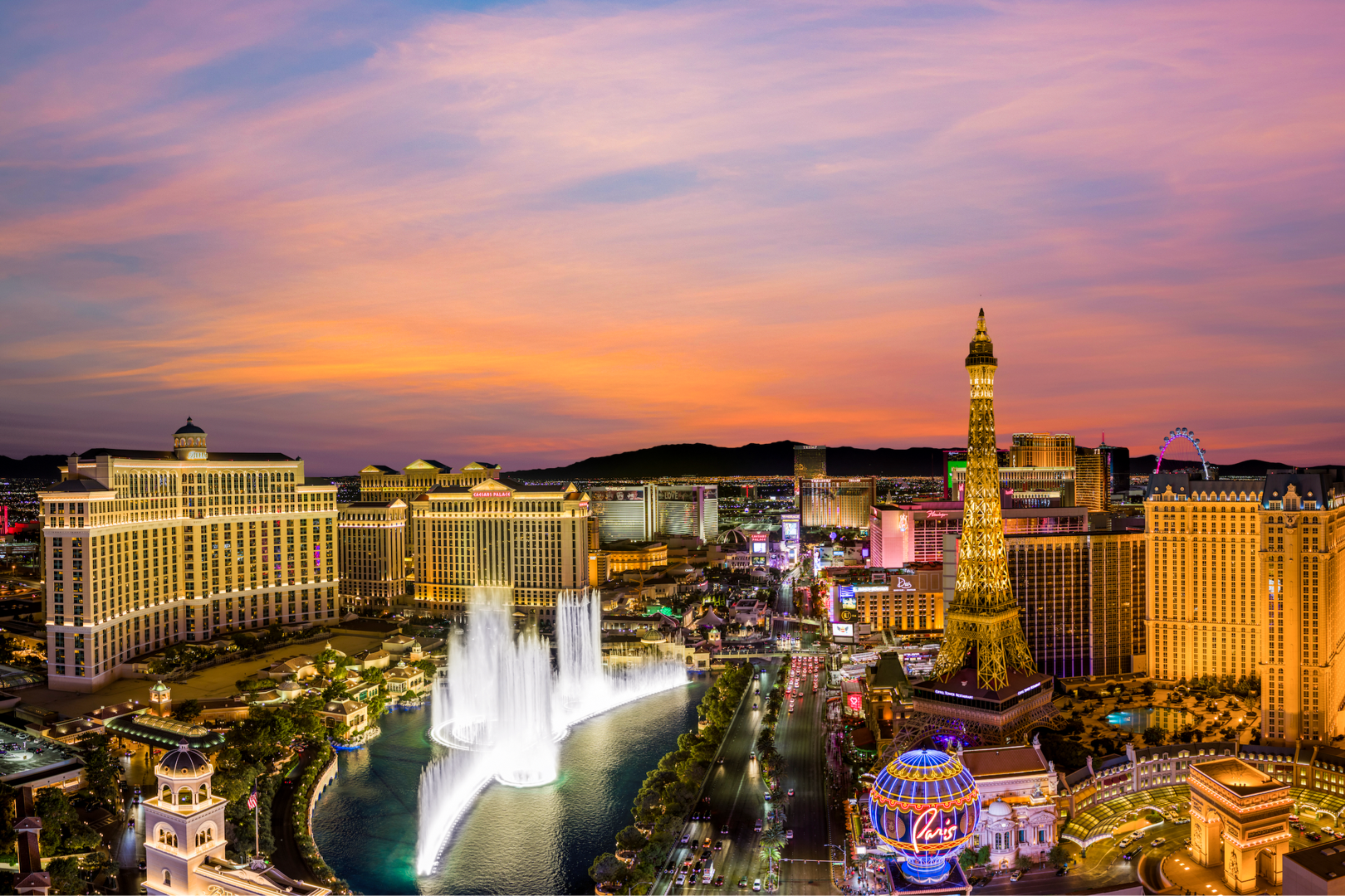 Beleuchtete Gebäude in Las Vegas und die berühmten Fountains of Bellagio bei Sonnenuntergang