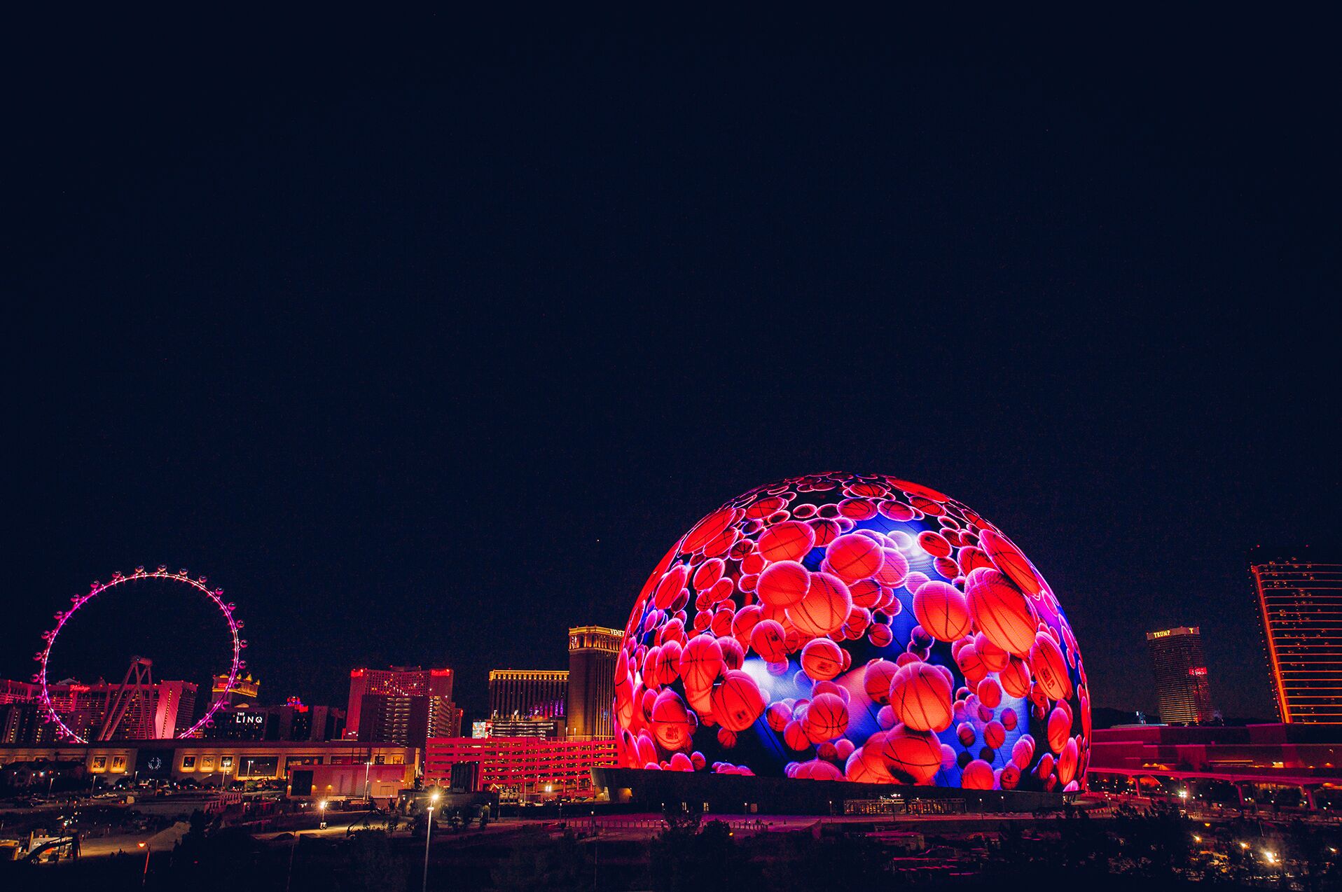 Die beleuchtete Sphere in Las Vegas zeigt Basketbälle, daneben steht ein Riesenrad