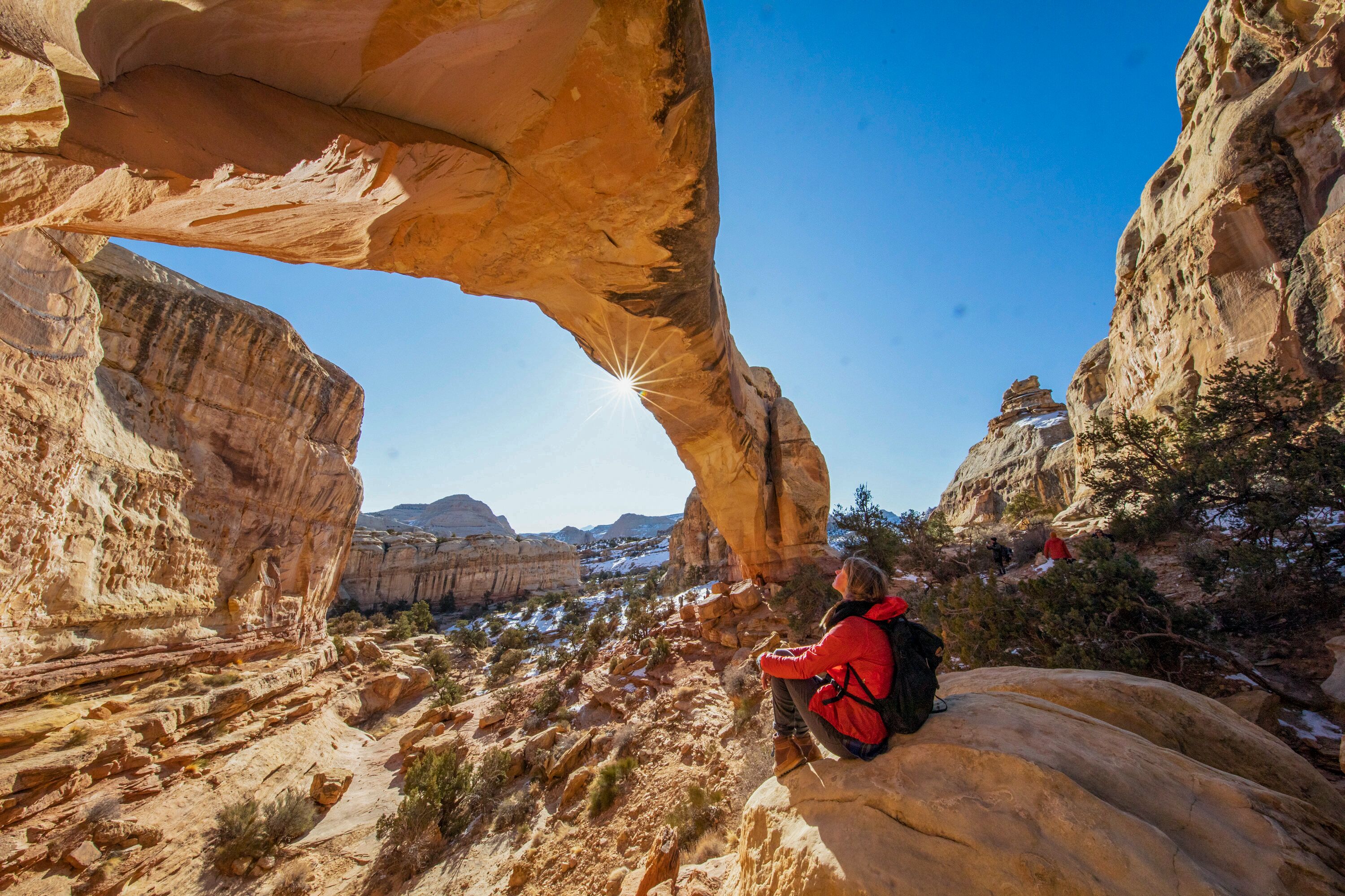Tourist sitzt unter der Hickman Bridge im Capitol Reef Nationalpark in Utah