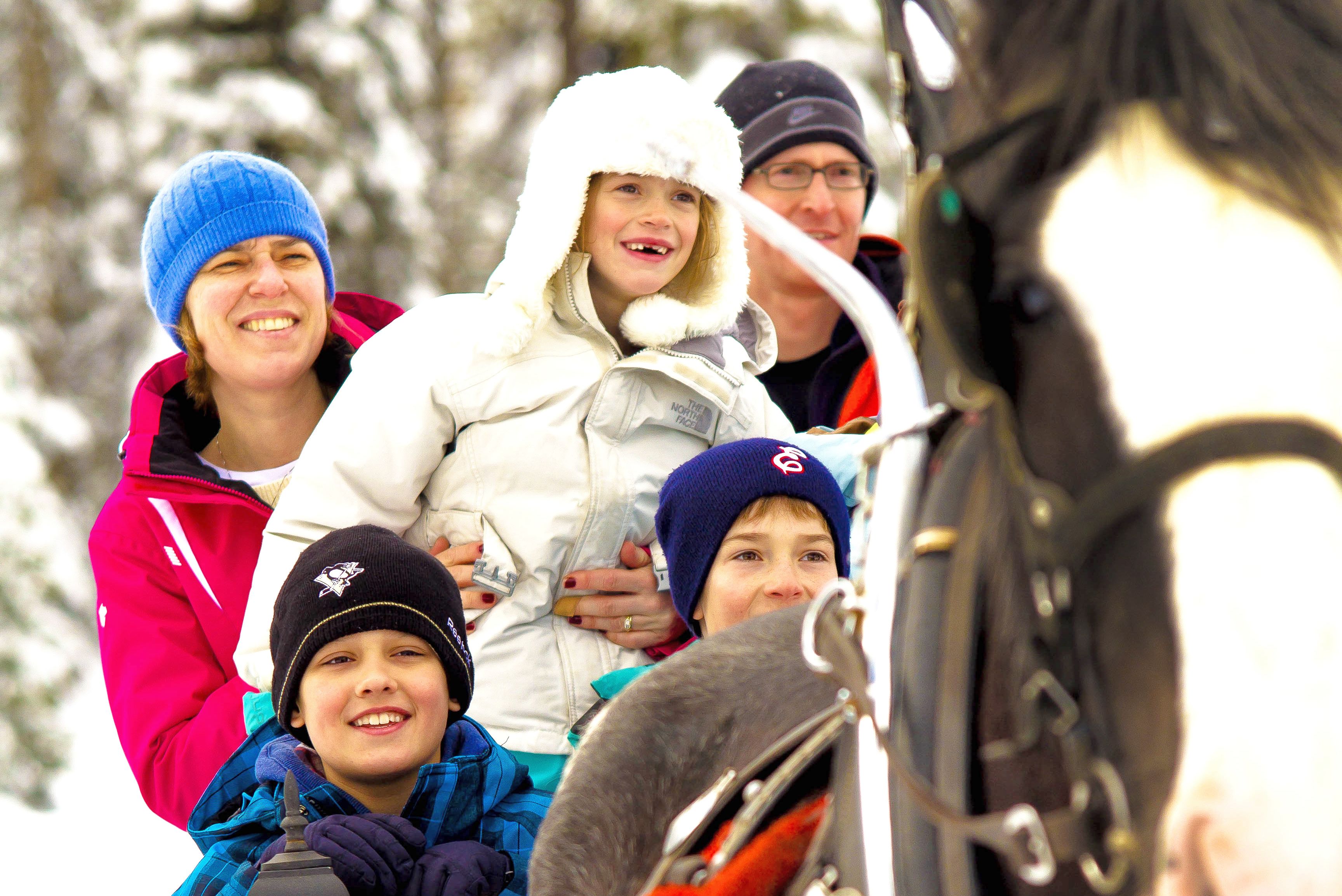 Familie auf Pferdeschlittenfahrt in British Columbia