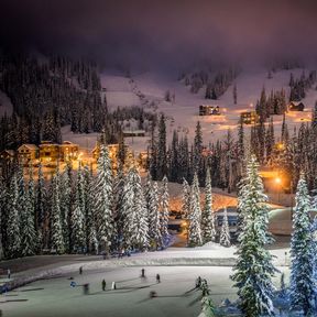 Beleuchtete Tannen säumen die Eisbahn des Silver Star Mountain Resort in Silver Star Mountain, British Columbia