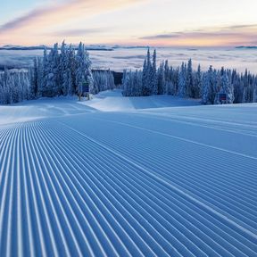 Die Sonne geht auf über einer Piste des Silver Star Mountains Resorts in British Columbia