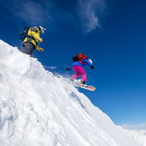 Snowboarderin und Skifahrer im Lake Louise Ski Resort in Kanada