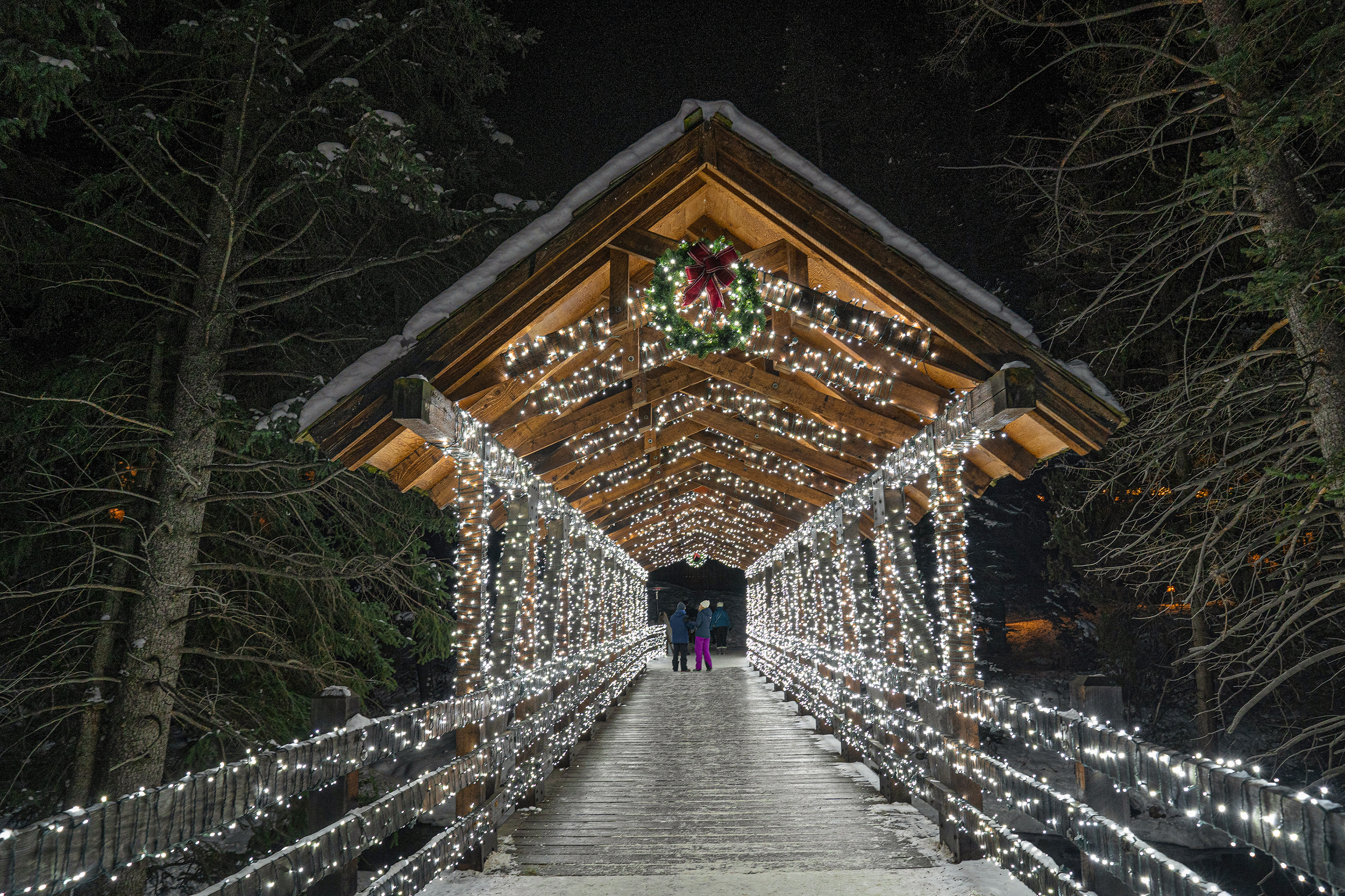 Magische Spaziergänge über beleuchtete Brücke durch den Wald im Vail Skiresort
