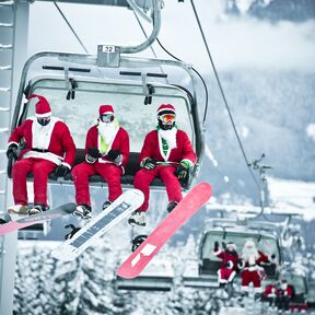 Snowboarder und Skifahrer in weihnachtlichen KostÃ¼men