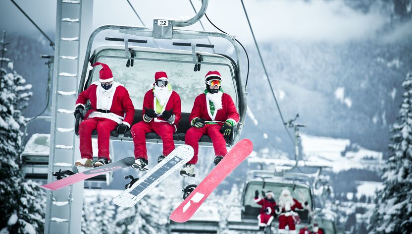 Snowboarder und Skifahrer in weihnachtlichen KostÃ¼men